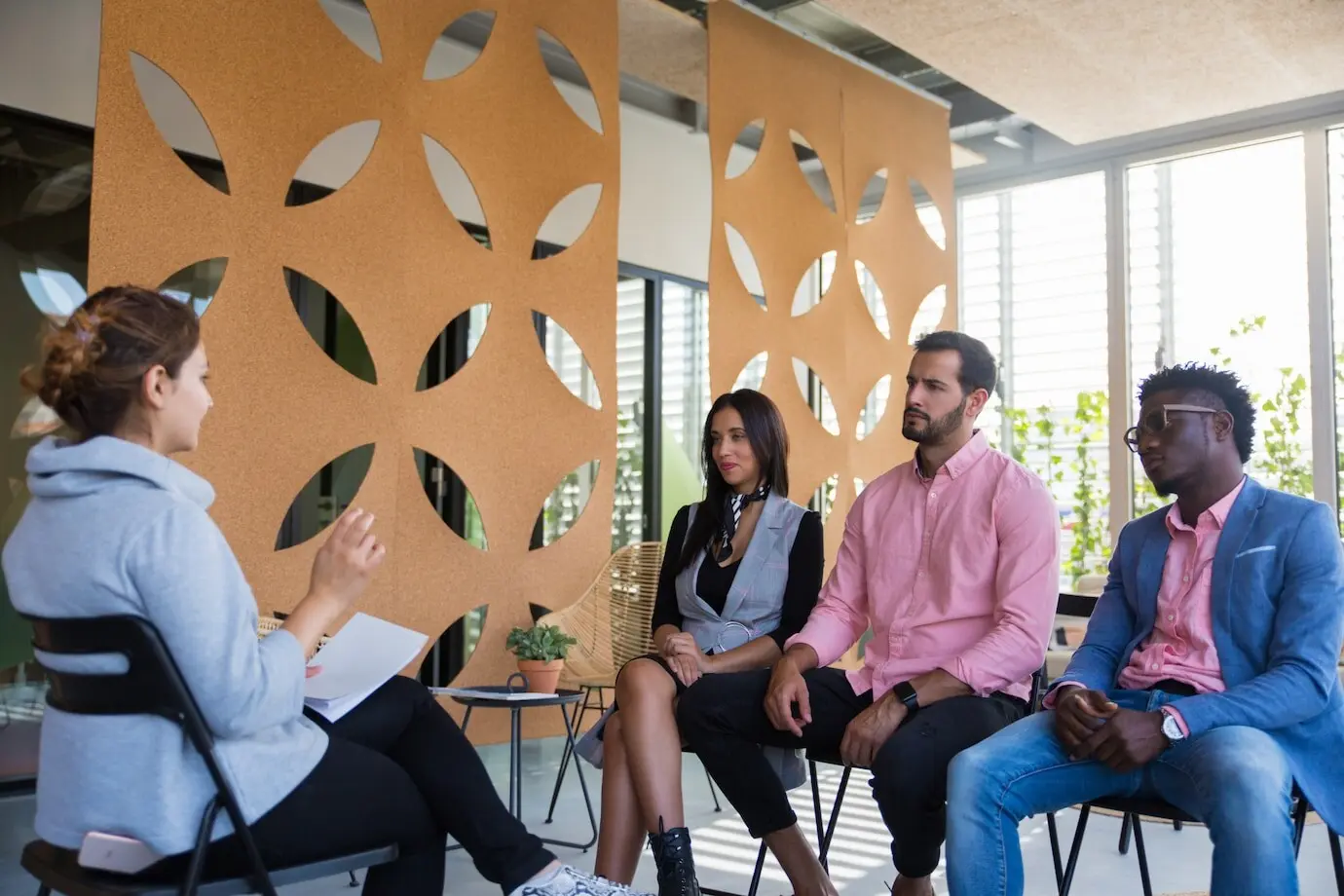 Vielfältiges Kollegenteam, das sich mit einem Coach berät.